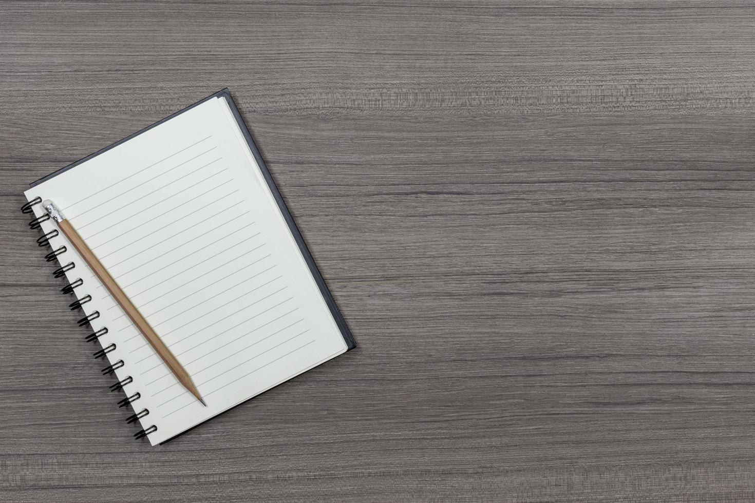 Top view notebook and pencil on wooden floor with copy space photo