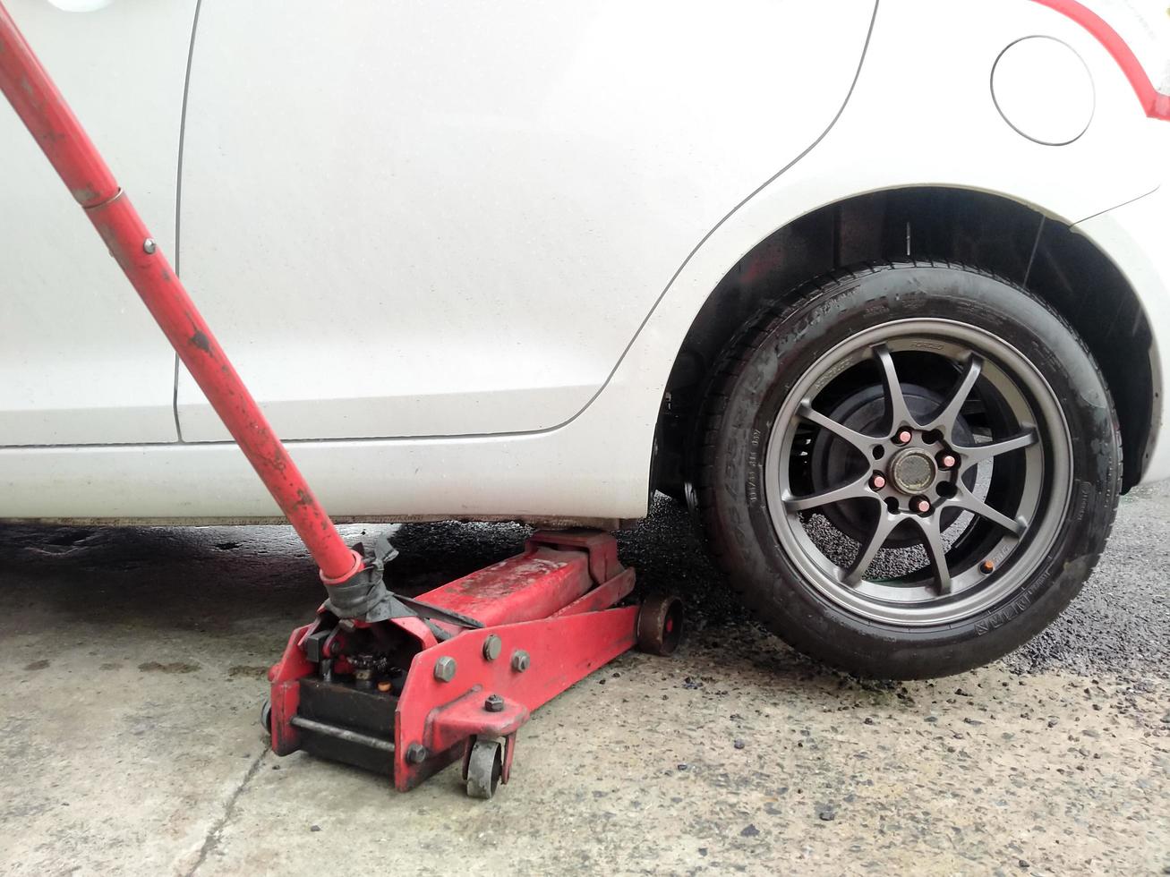 White cars change wheels using a lifting jack. photo