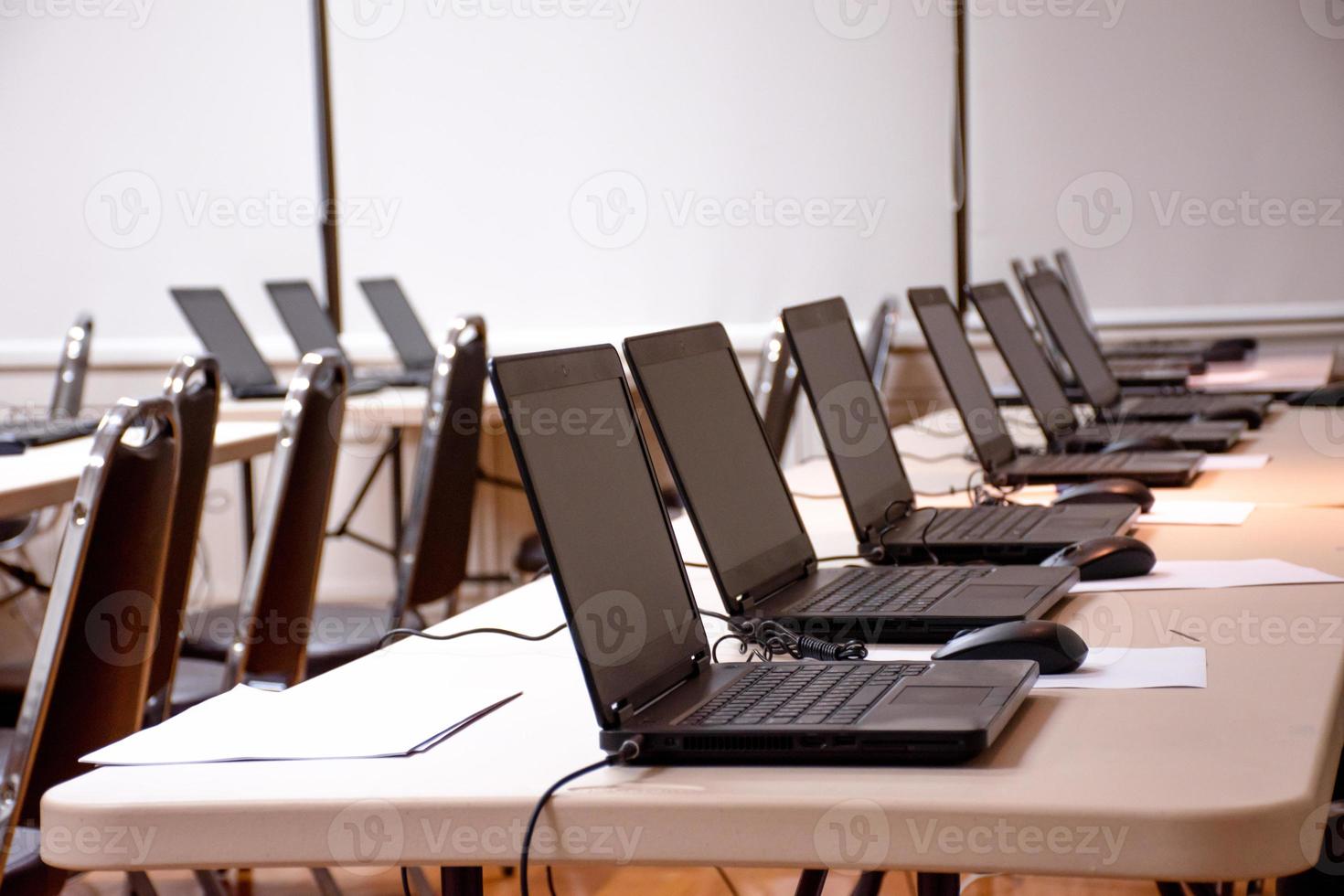Laptop arranging rows on table in seminar room photo