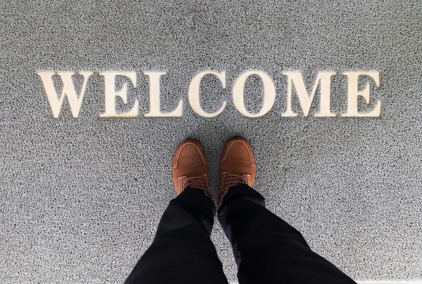 Overhead view of man standing on a welcome mat photo