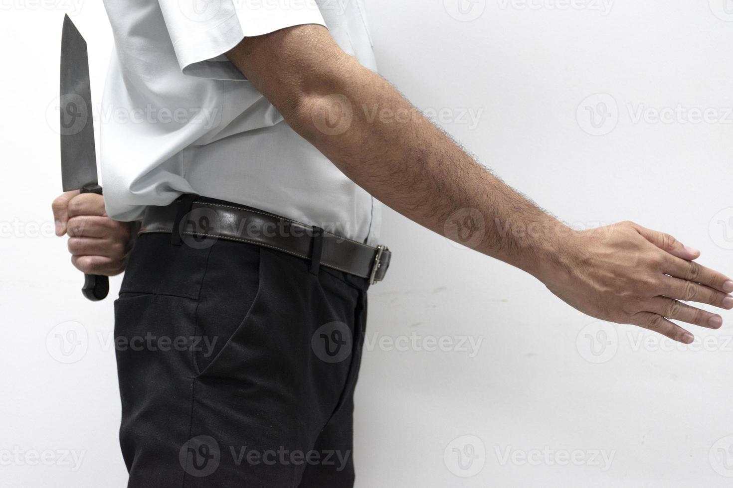 Blackmail concept Businessman open hands ready to shake hand and holding knife behind his back photo