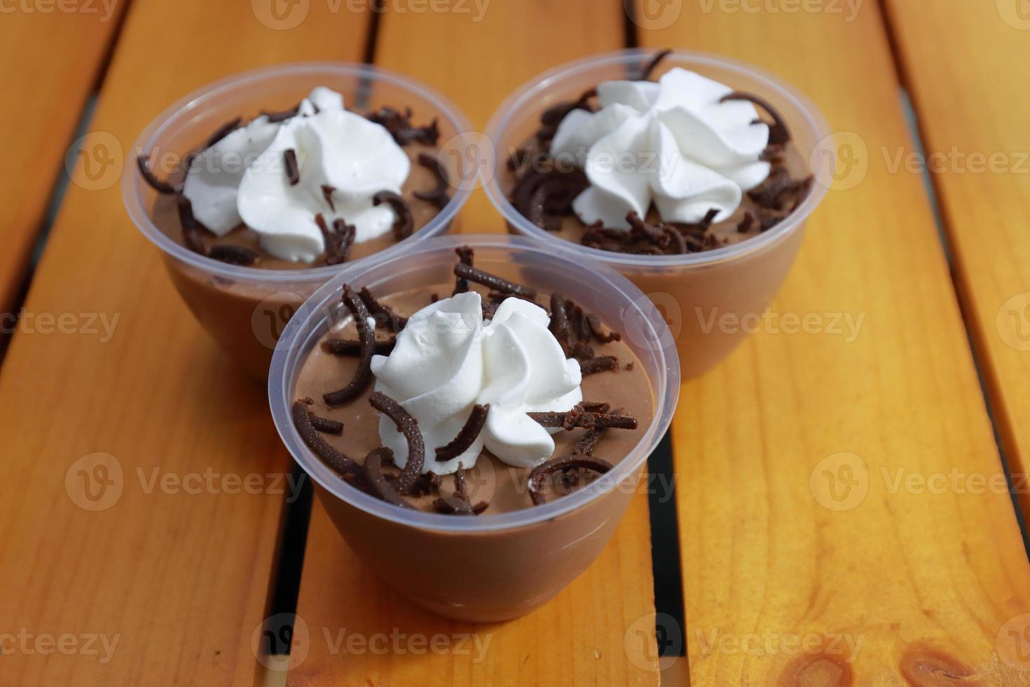 Elegant and delightful tasting chocolate mousse cups in wooden background photo