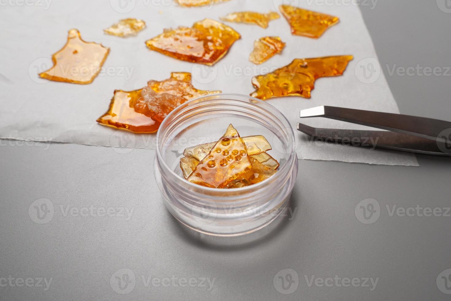 tweezers and pieces of cannabis wax put in a box photo