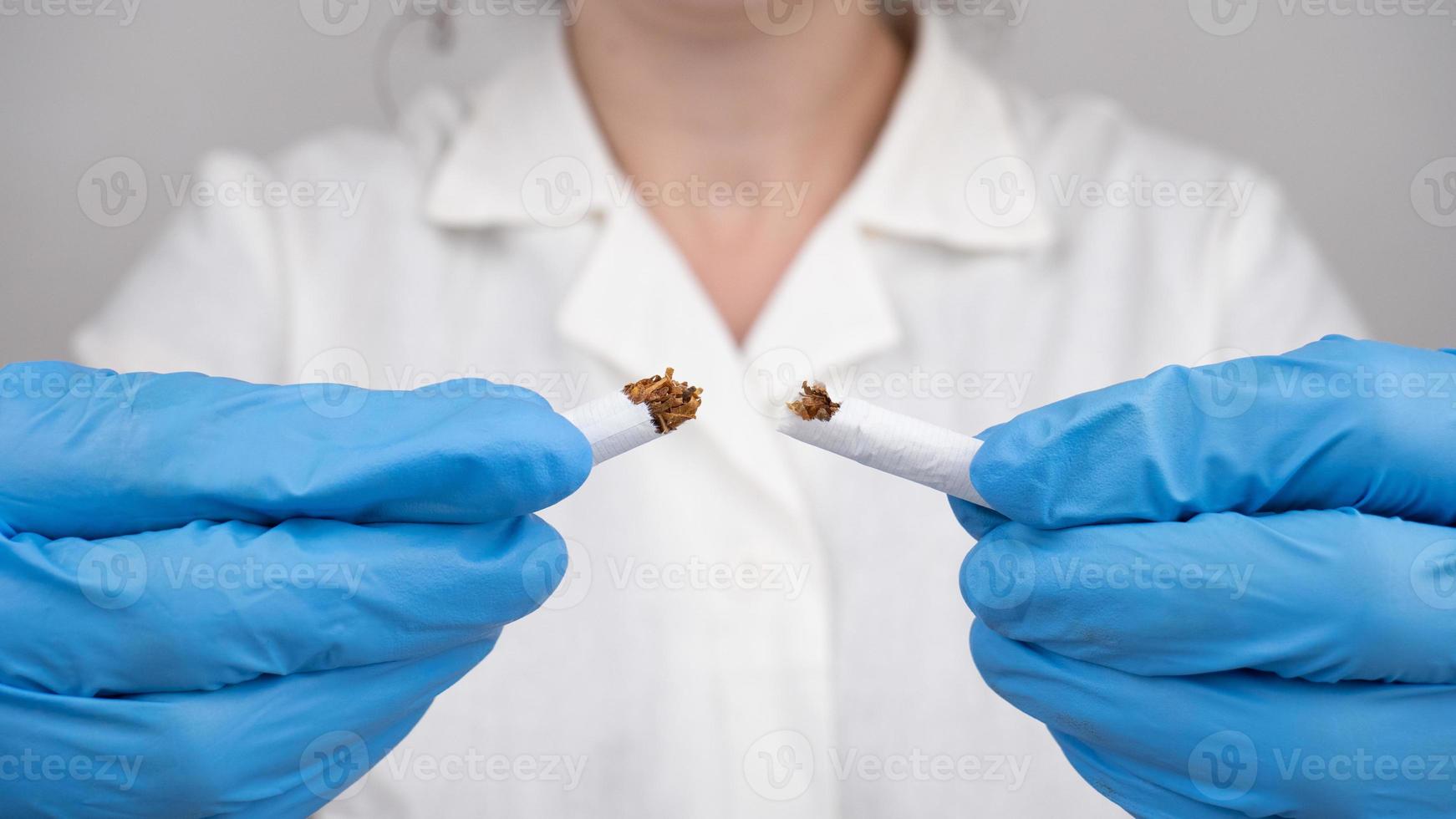 stop smoking, a broken cigarette in the hands of a doctor photo