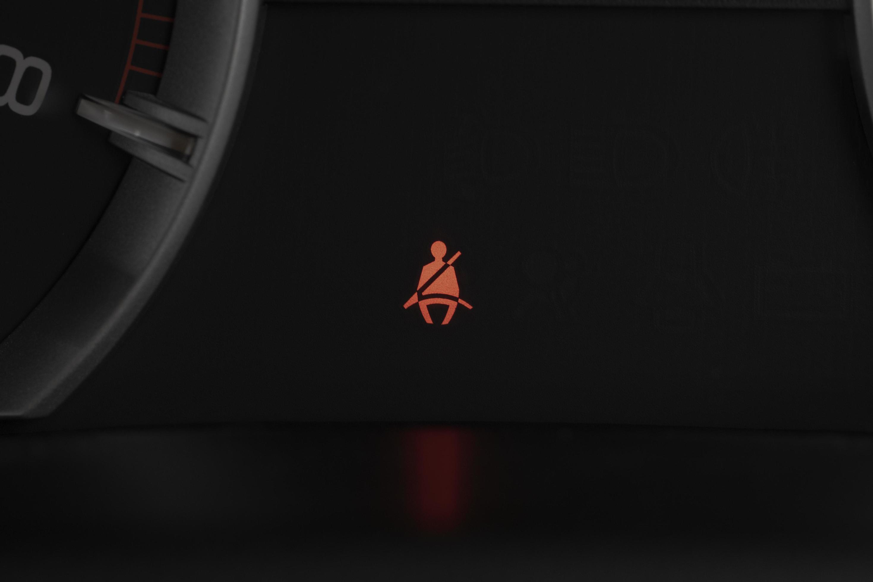 Seat belt warning light on car dashboard. Safety restraint law, safety