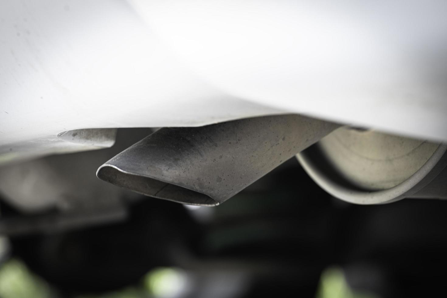 Low angle view of the car's exhaust pipe with focus on the exhaust pipe, white car. photo