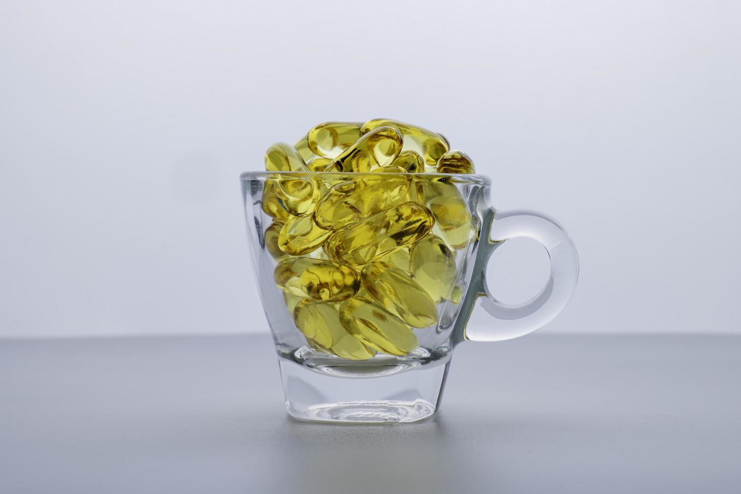 omega 3 fish oil The capsule is in a clear glass. isolated on a white background. photo