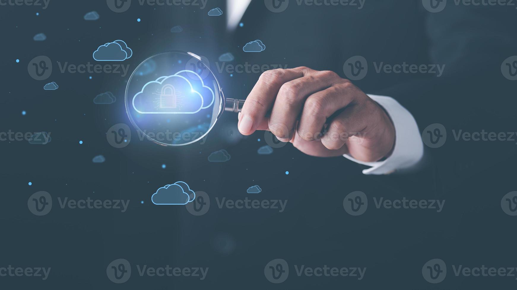 businessman holding a magnifying glass shows the use of cloud network technology to communicate and connect data servers around the world. with the innovation of online internet from virtual screen photo