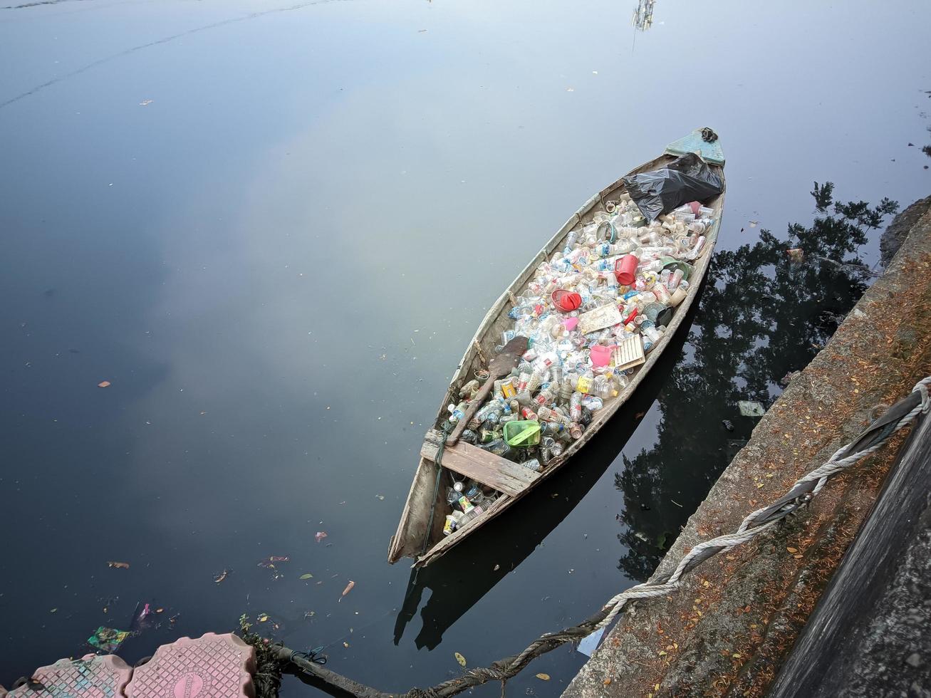 pequeños botes que transportan basura en el río. ubicado en la ciudad de daan mogot, jakarta, 13 de agosto de 2022. foto