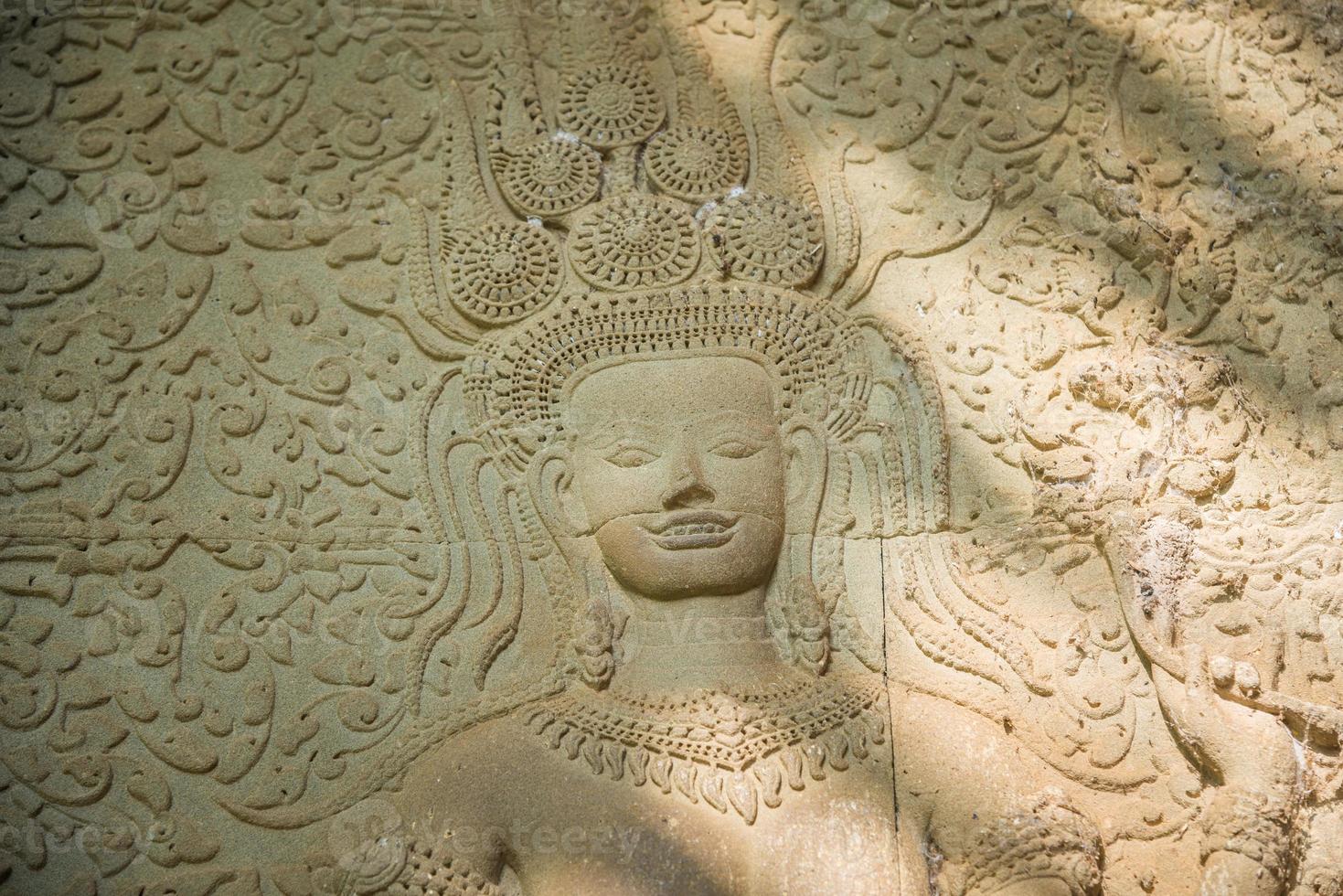 One of an iconic APSARA bas-relief who shows her teeth with a smile in Angkor Wat of Siem Reap, Cambodia. Apsara is a type of female spirit of the clouds and waters in Hindu and Buddhist culture. photo