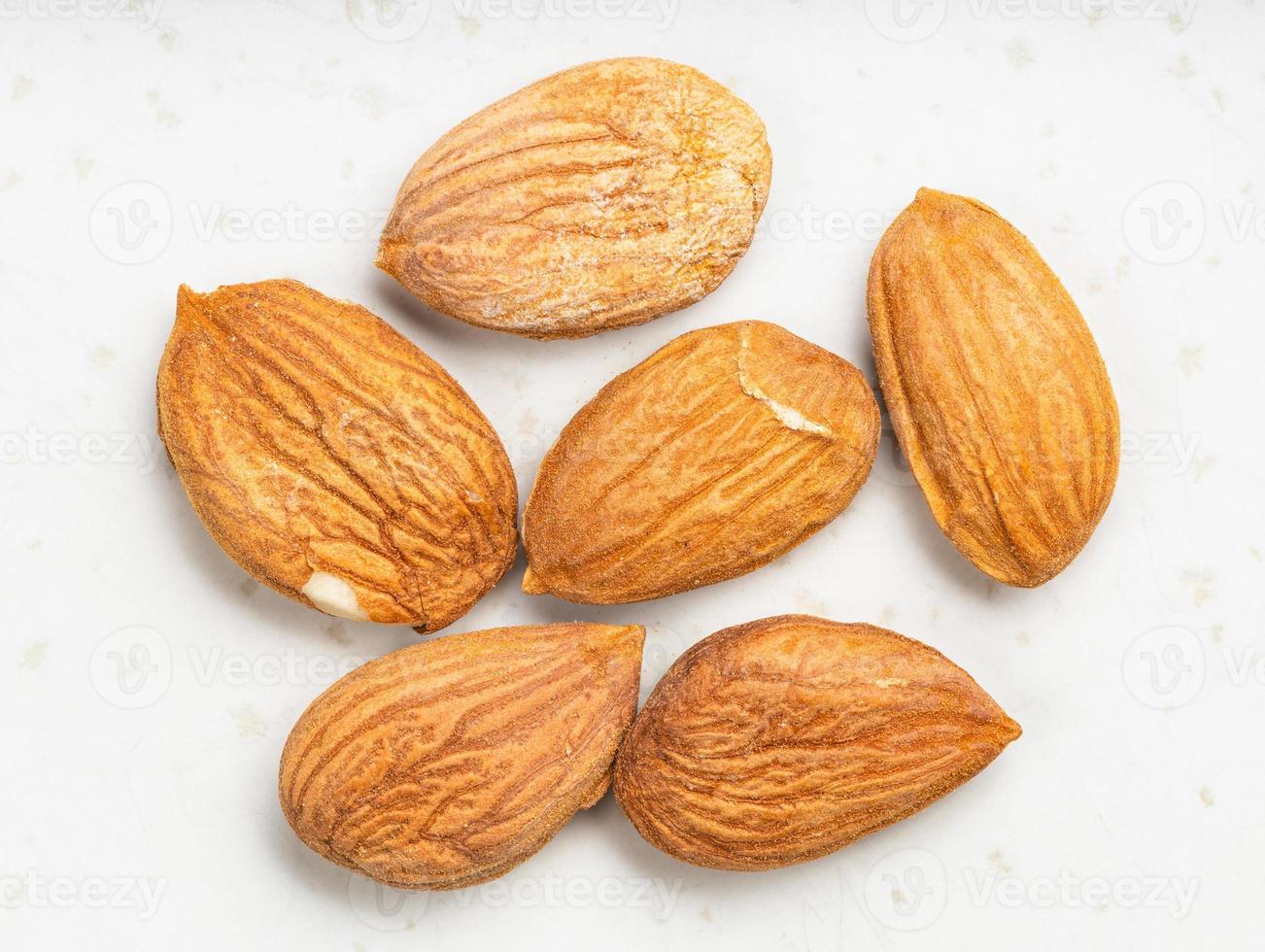 several raw apricot kernels close up on gray photo