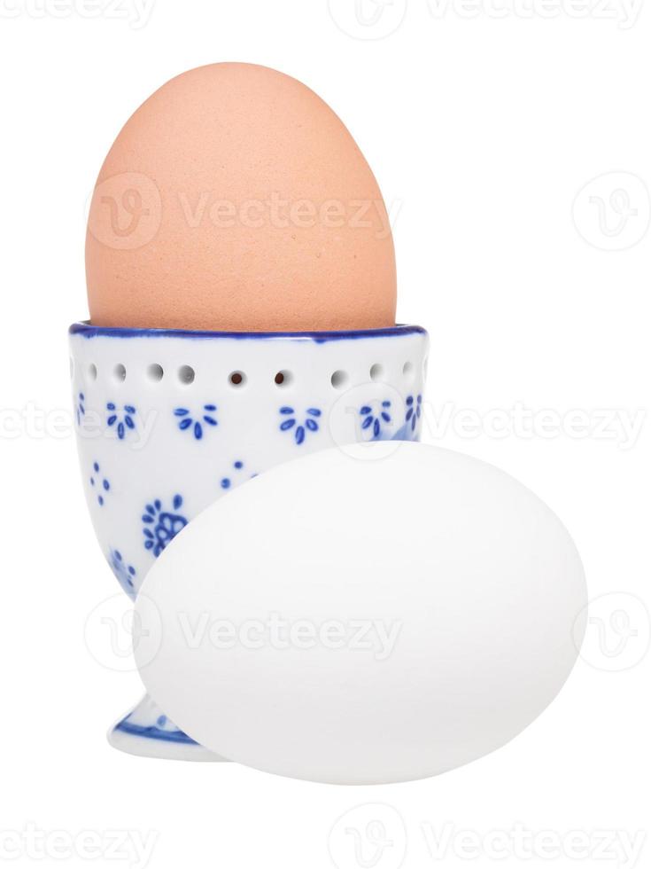 white egg and brown boiled egg in ceramic egg cup photo