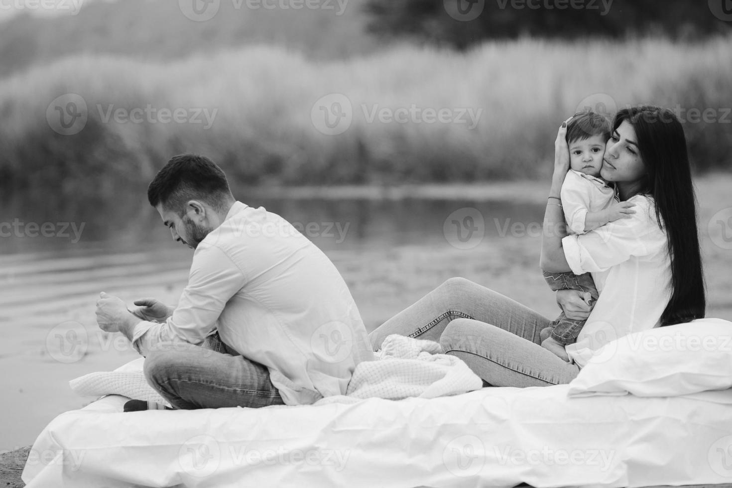 Happy young family relaxing together on the lake photo