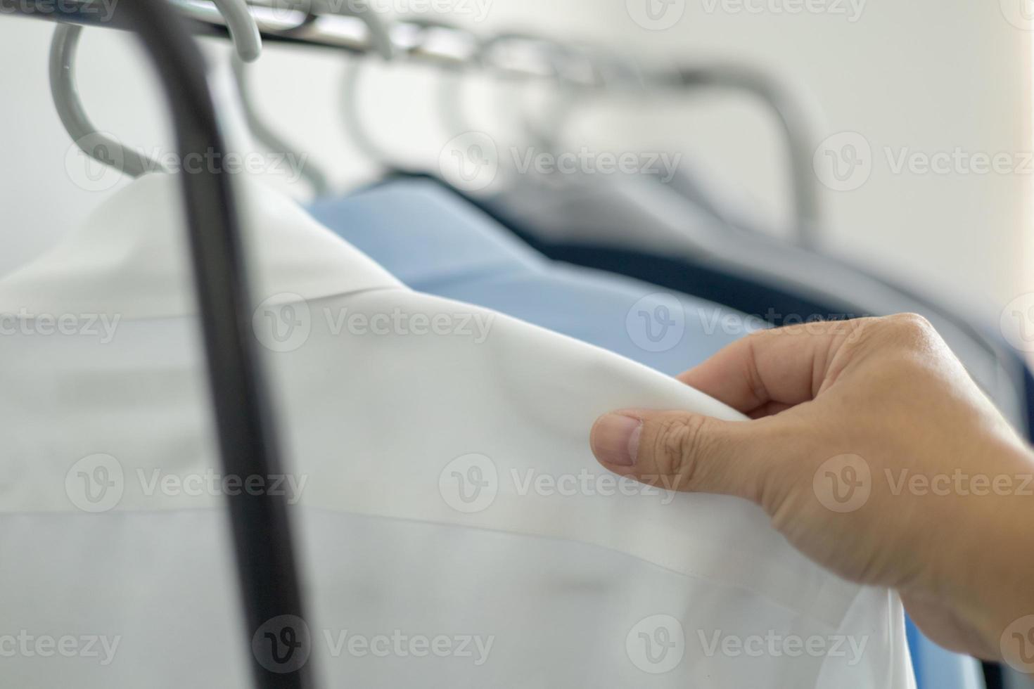 man is choosing shirt in the clothes room at home. photo