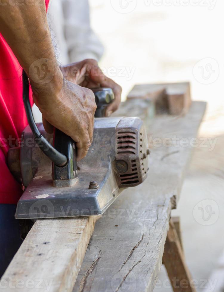 Carpenter working with electric planer photo