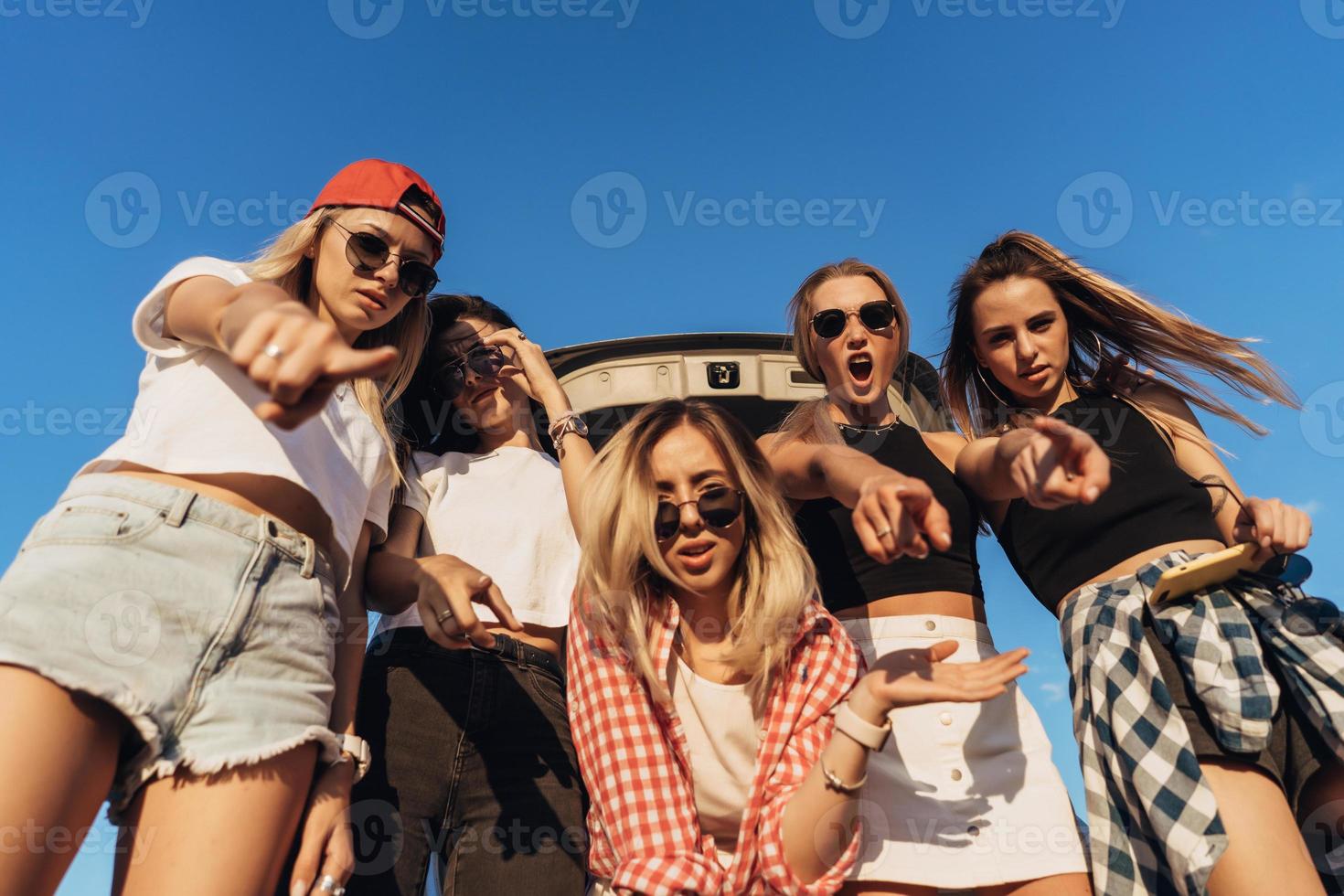 Five young woman looking in the camera the car park. photo