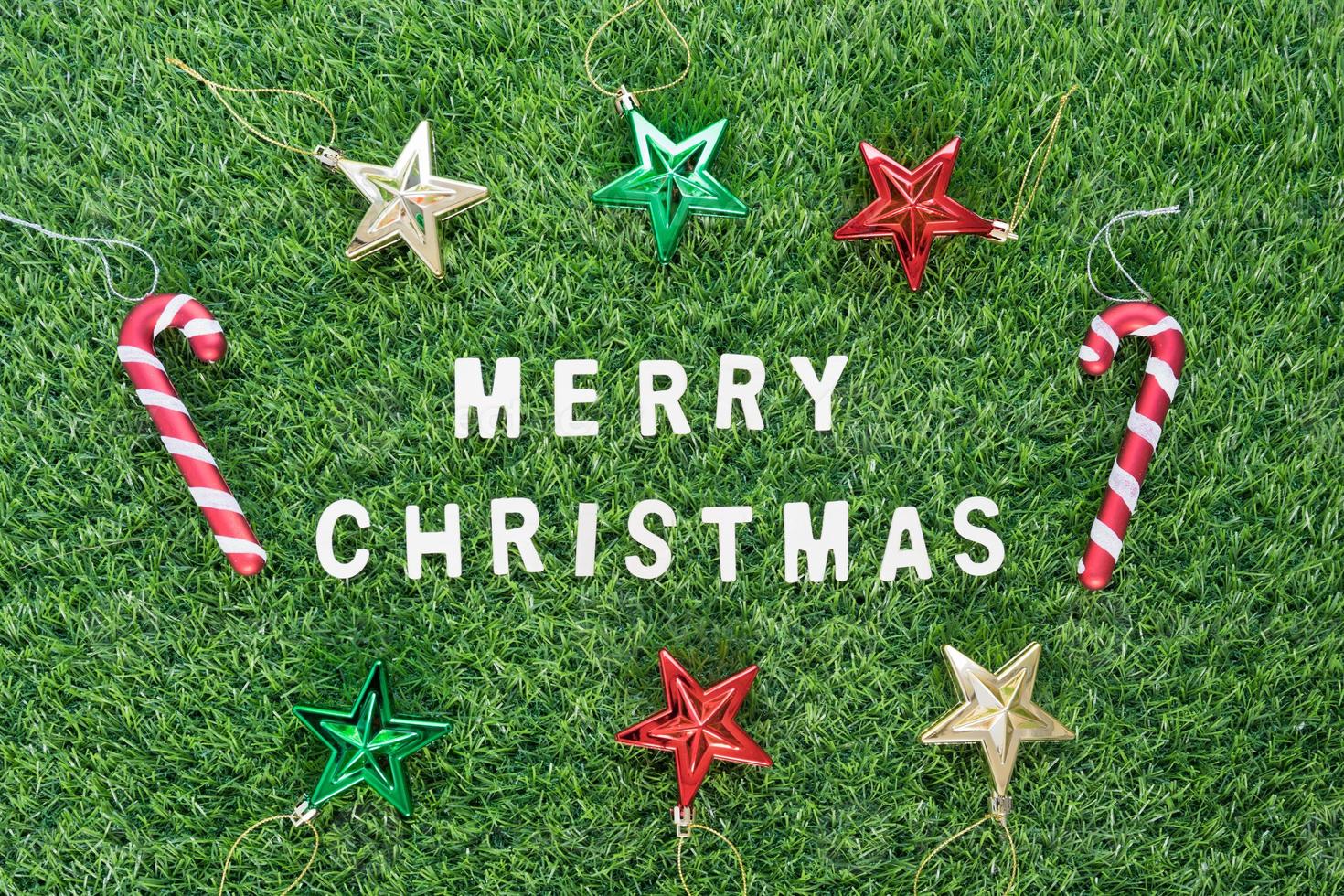 Christmas alphabet and decoration on green grass photo