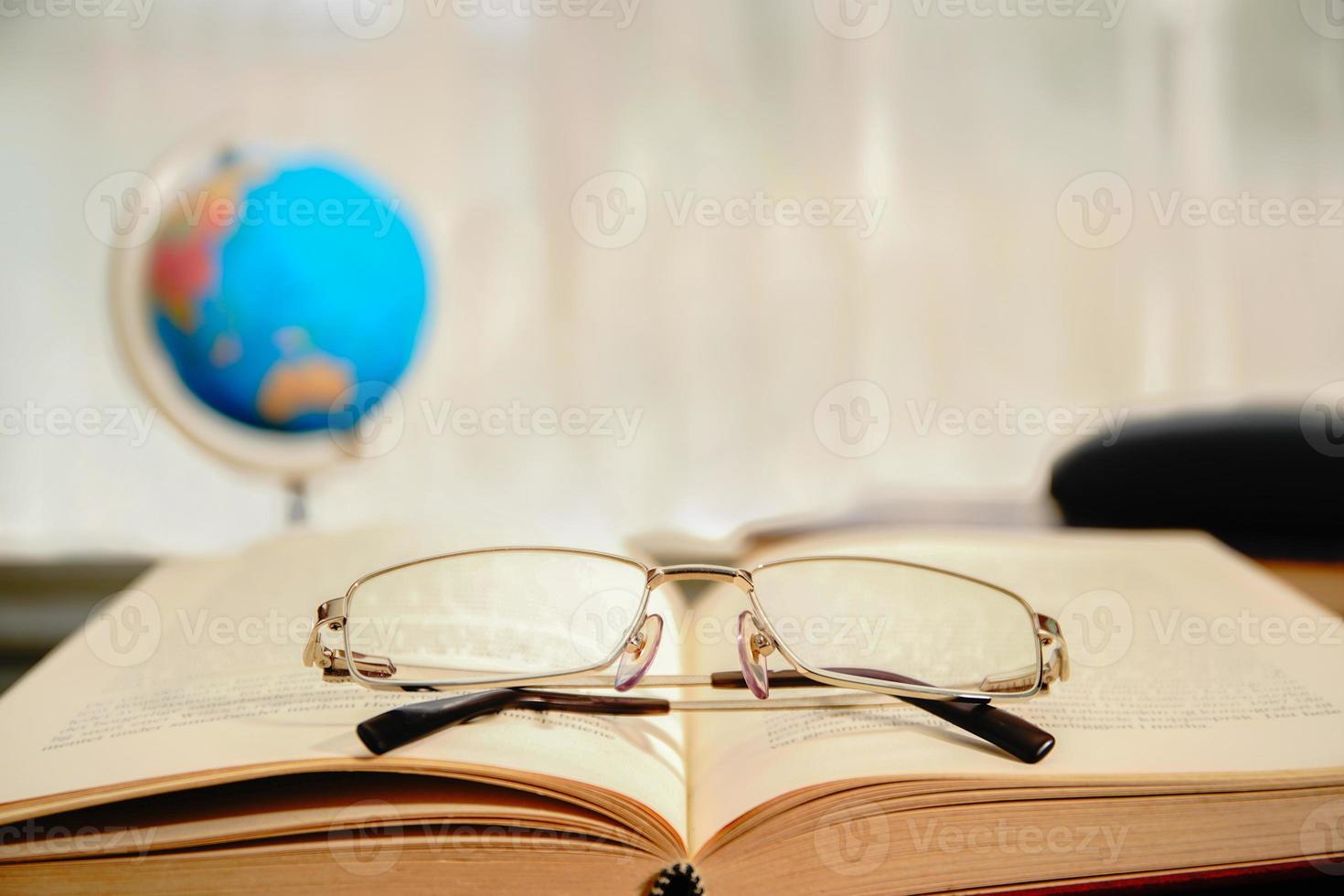 Reading glasses put on open book photo