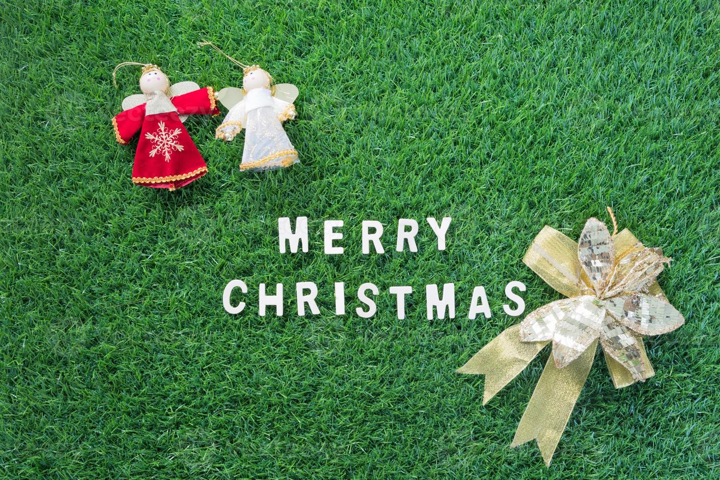 Christmas alphabet and decoration on green grass photo