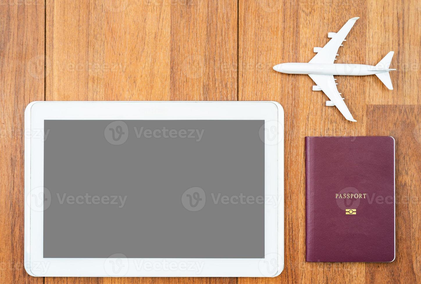 Digital tablet mock up and airplane with passport on desk photo