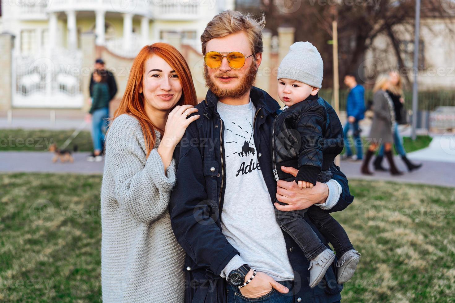 happy mom dad and son hugging in the park photo