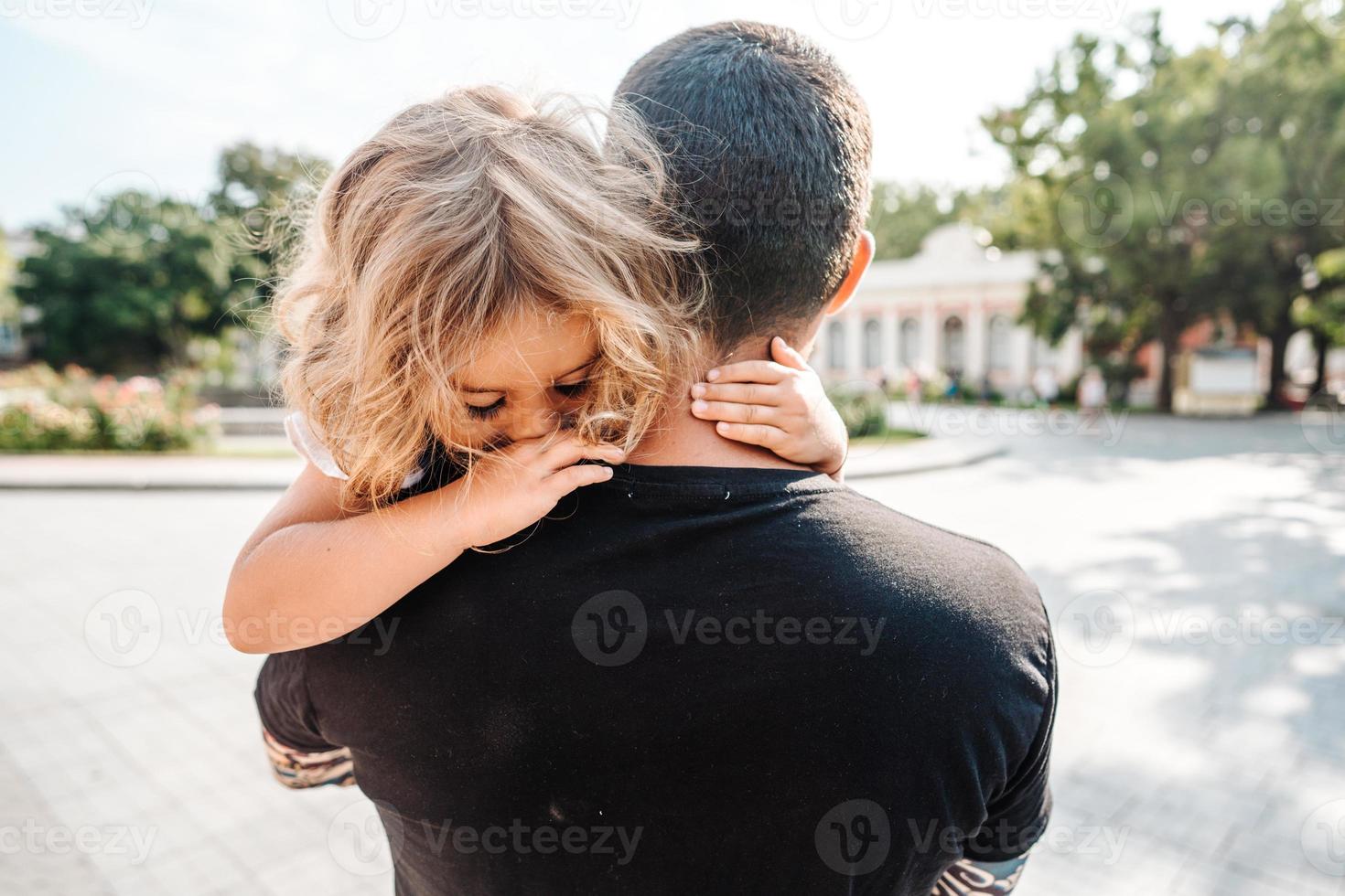 Little girl resting on her father's shoulder photo