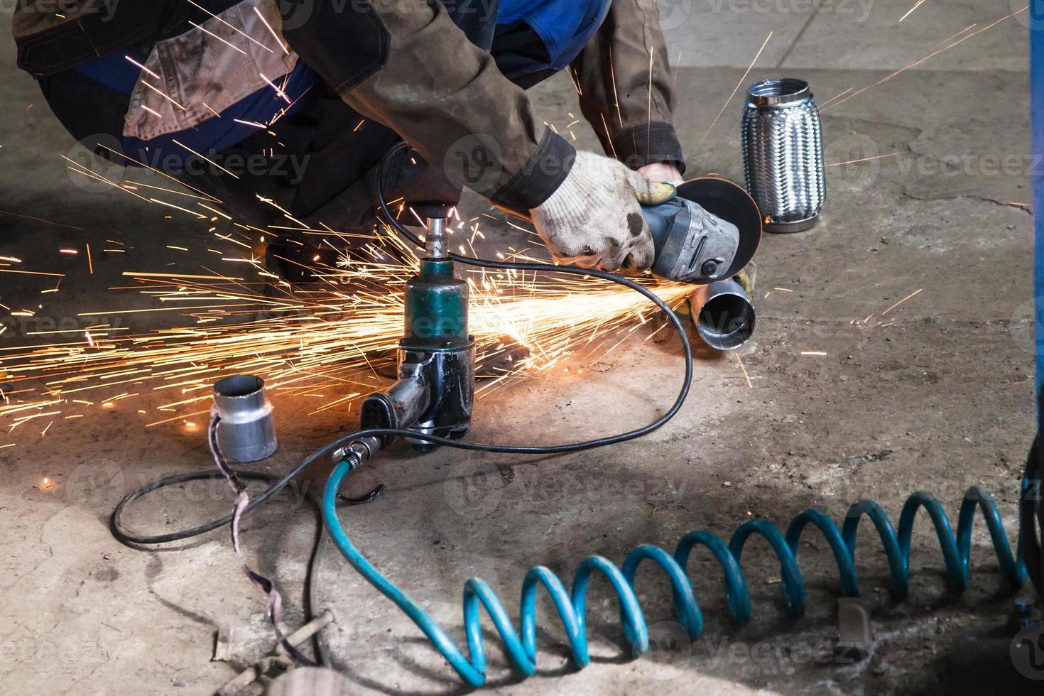 mechanic cuts new pipe for corrugation silence photo