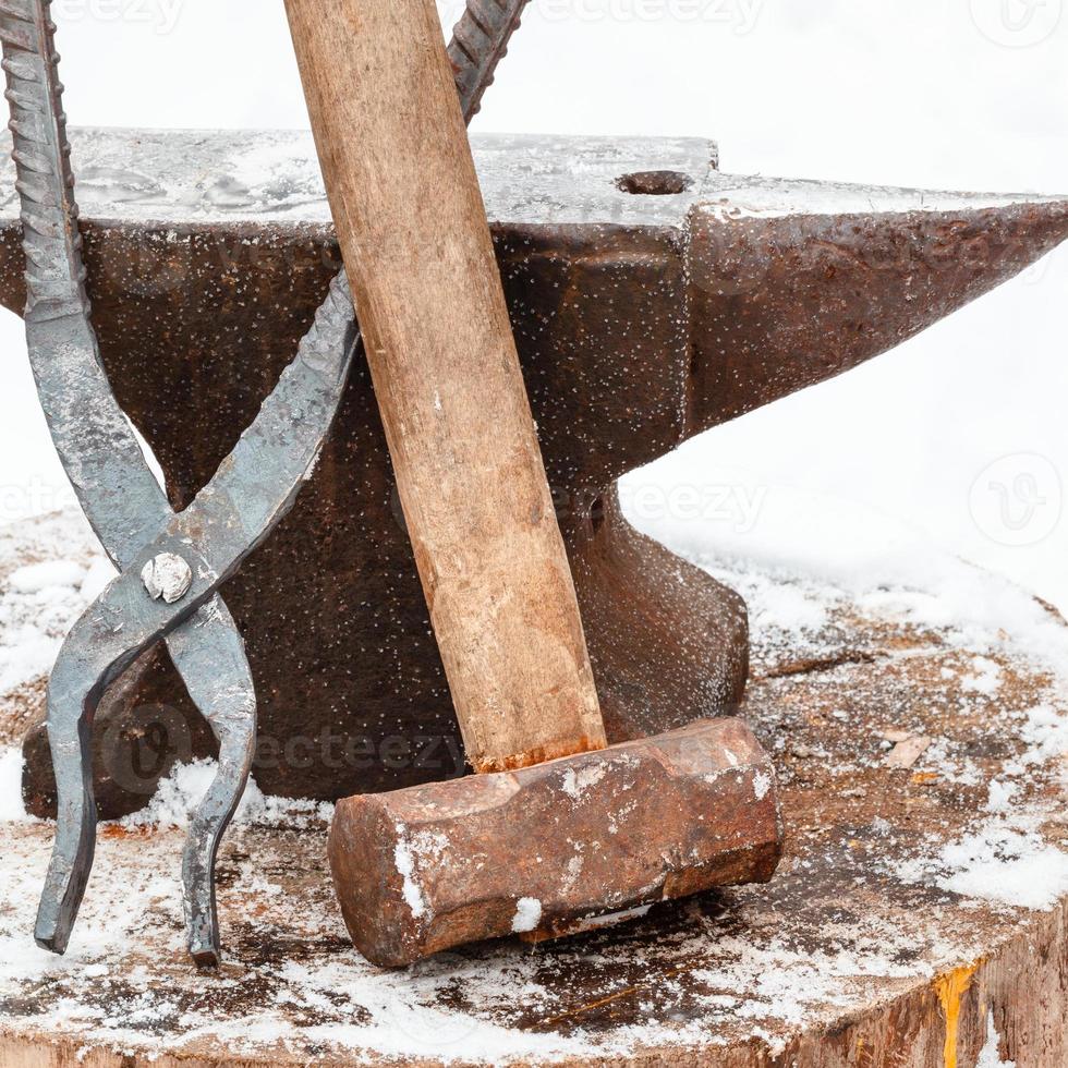 anvil with tongs and hammer in rural smithy photo