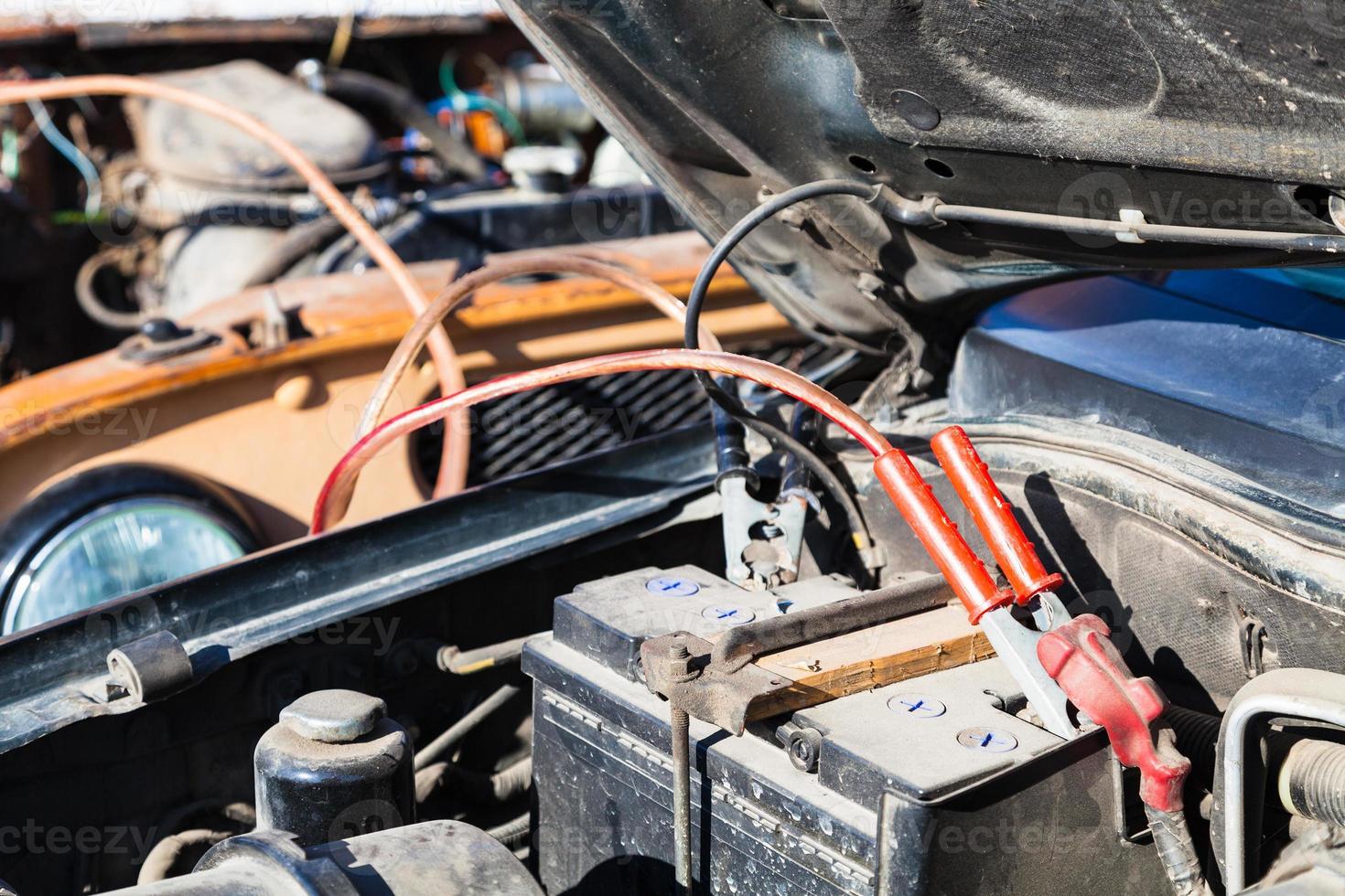 Jump starting old car battery with another vehicle photo