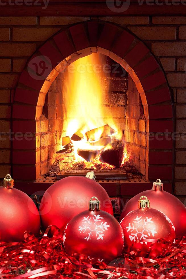 red Xmas baubles and tinsel with home fireplace photo