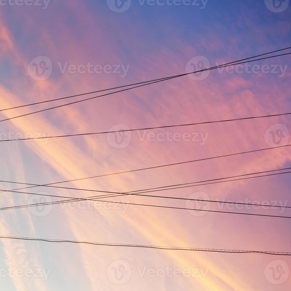 cables de energía eléctrica y nubes rosadas al atardecer foto