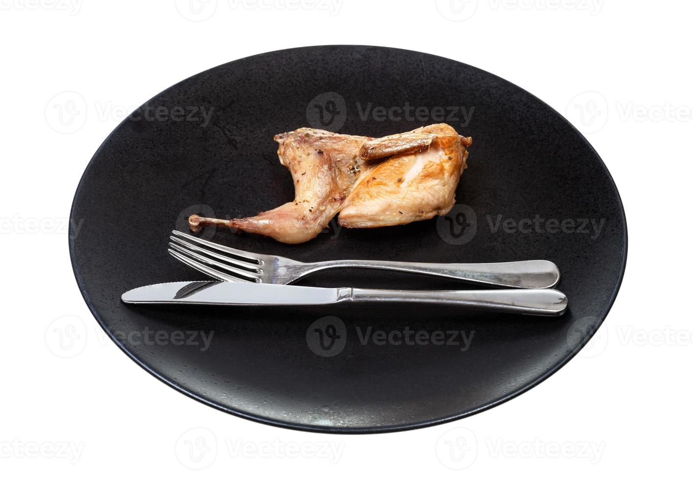 half of fried quail on plate with fork and knife photo