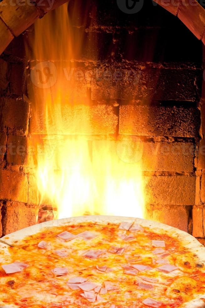 pizza with prosciutto cotto and fire flame in oven photo