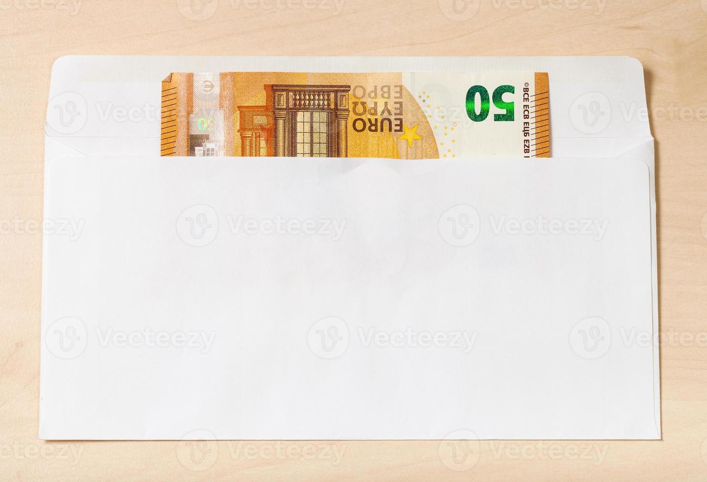 single fifty euro note in open envelope on table photo