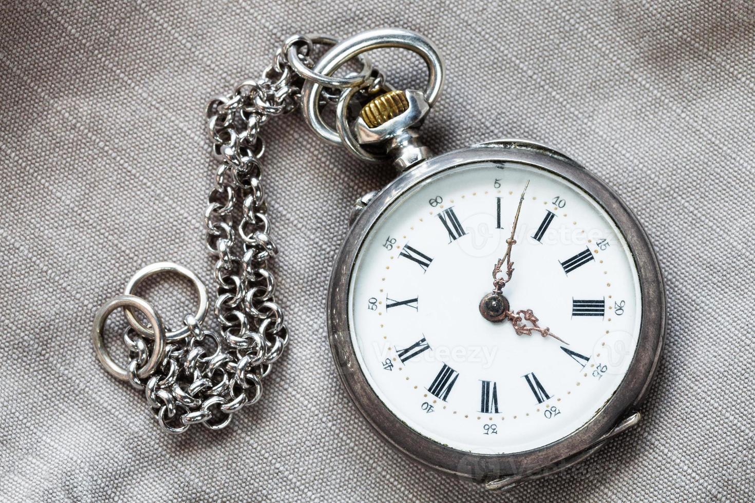 pocket watch with chain on textile background photo