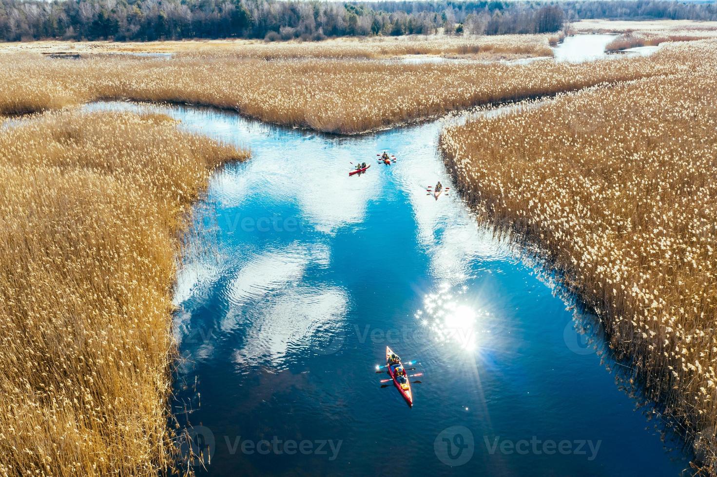 Group of people in kayaks among reeds on the autumn river. photo