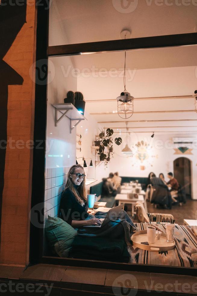 mujer trabaja en un café por la noche foto