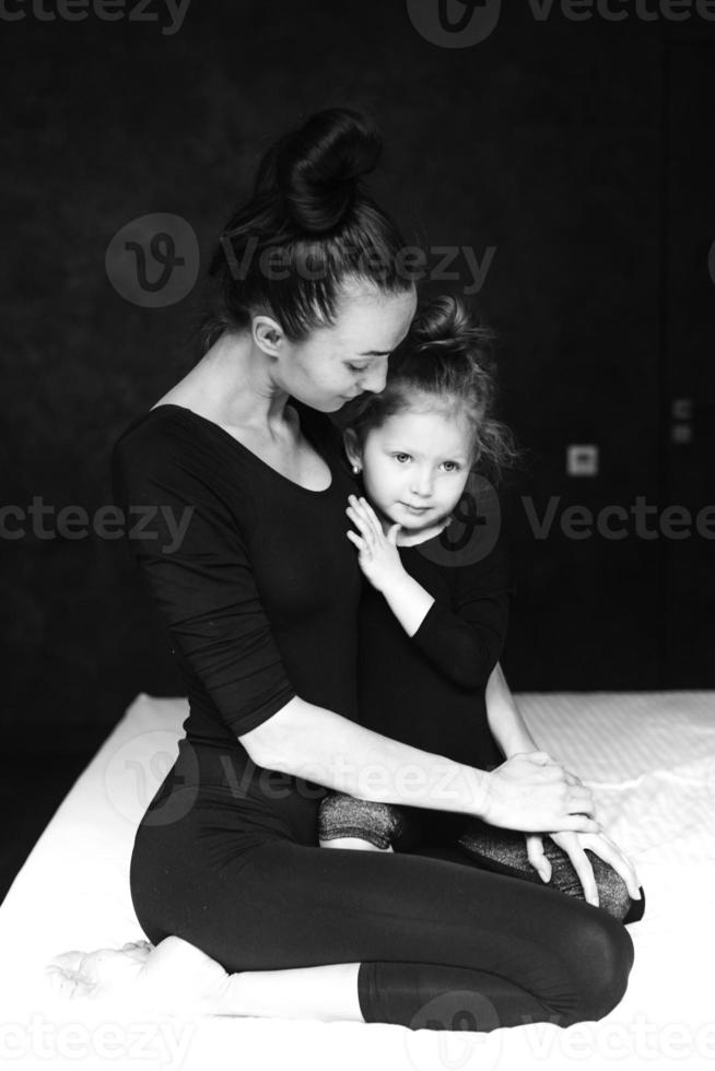 Mom and daughter have fun on the bed photo