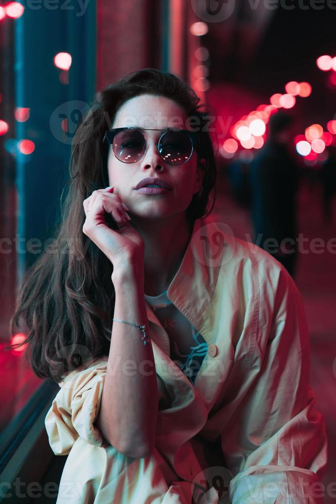 Night in the city, beautiful woman among red lights. photo