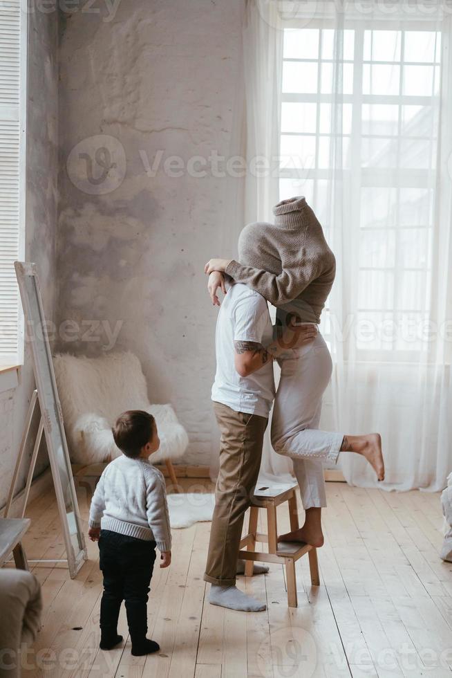 Dad and mom play hide and seek with their little son photo