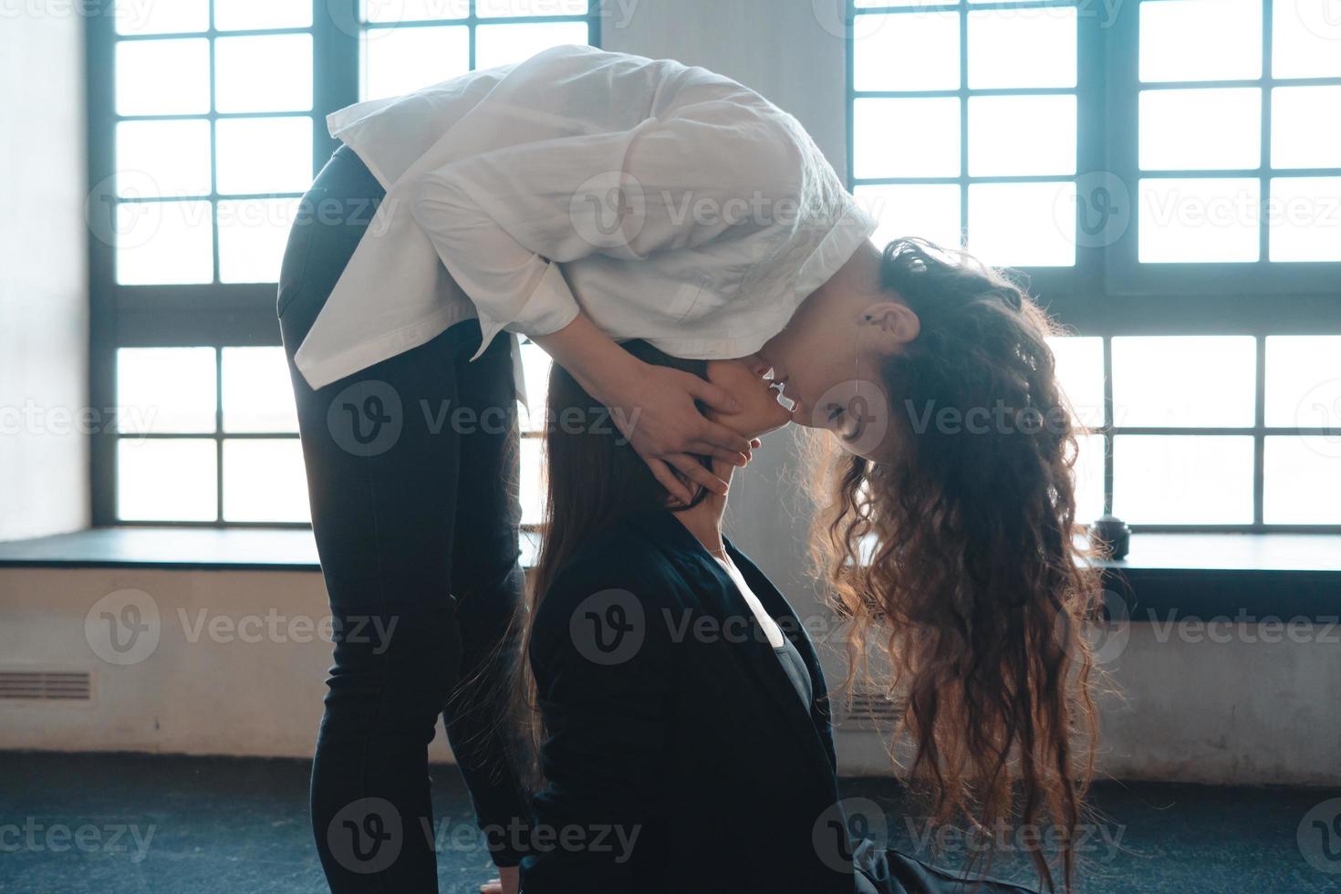 Close up young woman thoughtfully kissing woman at home photo