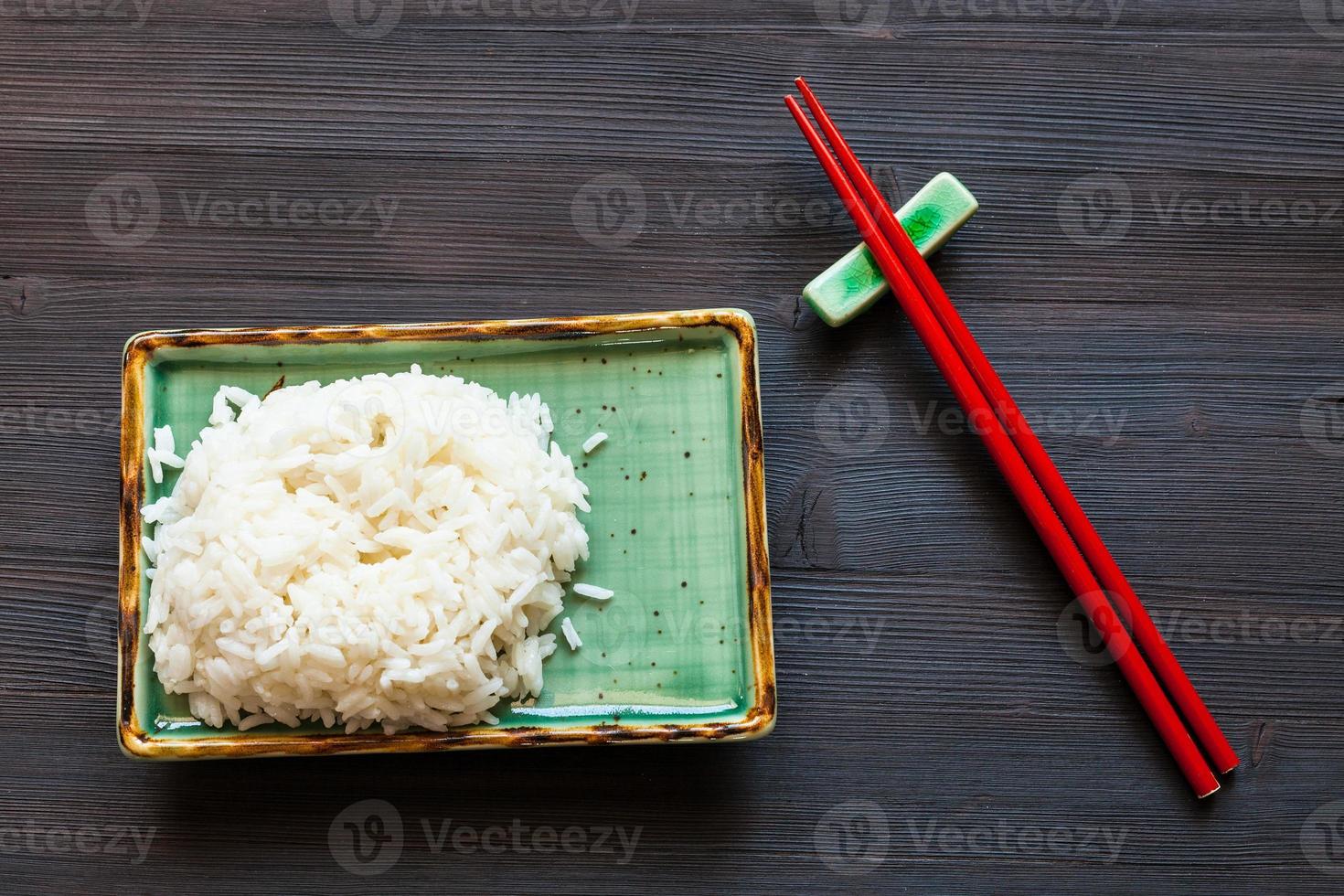 boiled rice on green plate and red chopsticks photo