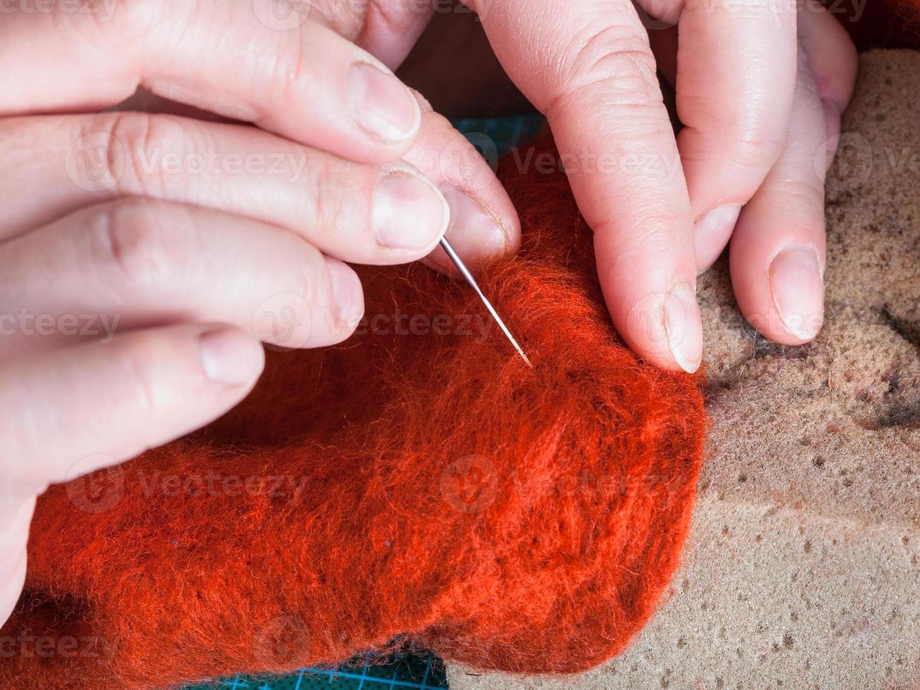 craftsman mixes fibers with felting needle photo