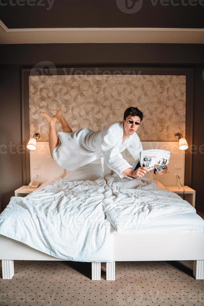 Guy with sunglasses and newspaper high in air. photo