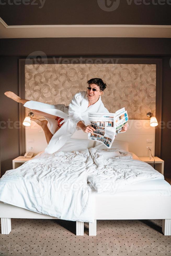 Guy with sunglasses and newspaper high in air. photo