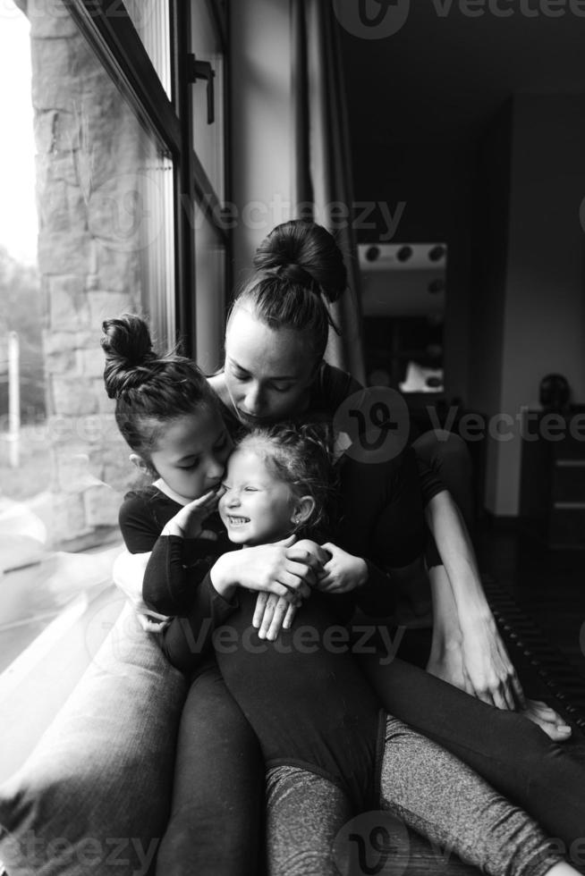mamá y dos hijas juntas en la ventana foto