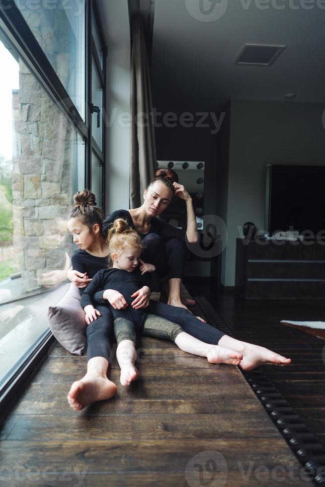 Mom and two daughters together at the window photo