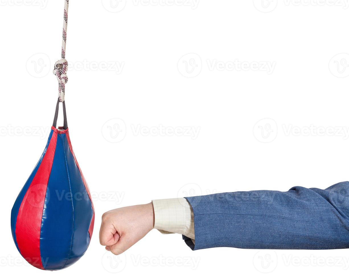 man in office suit punches punching bag isolated photo