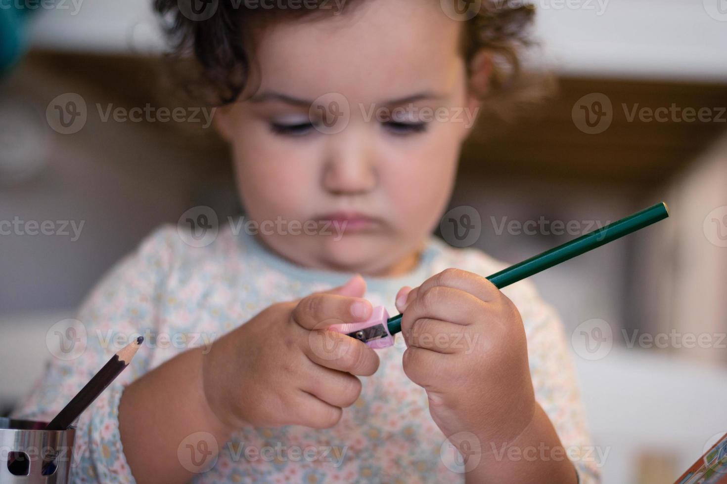 Close up of child using pencil sharpener. photo