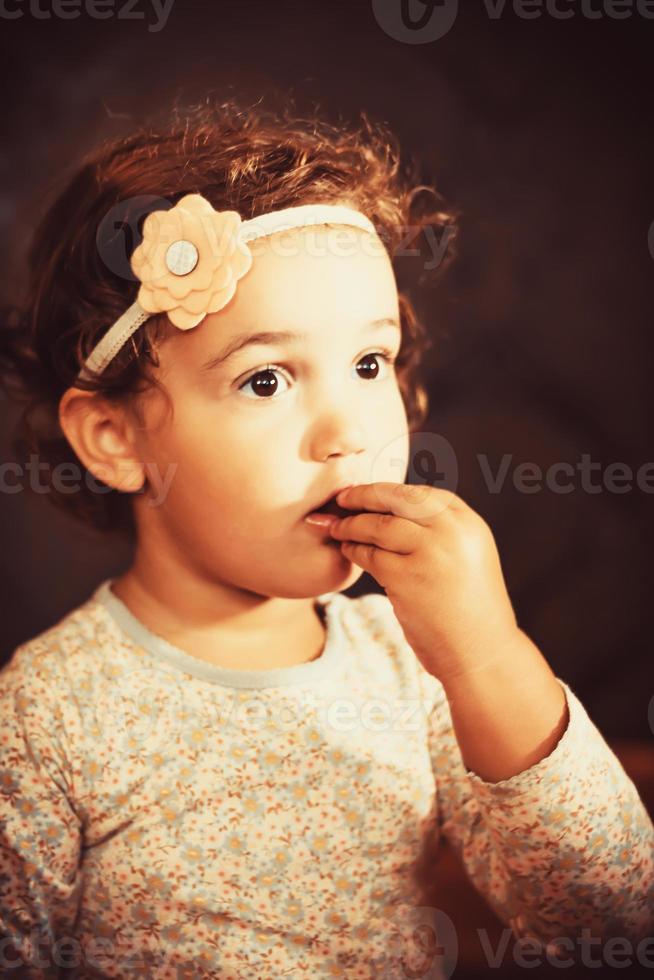 linda niña pequeña comiendo un bocadillo. foto